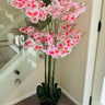 Pink artificial orchid plant in a pot indoors