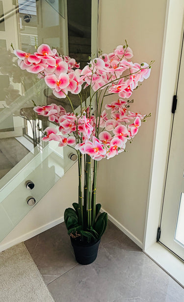 Pink artificial orchid plant in a pot indoors
