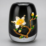 Decorative black vase with floral design on a white background